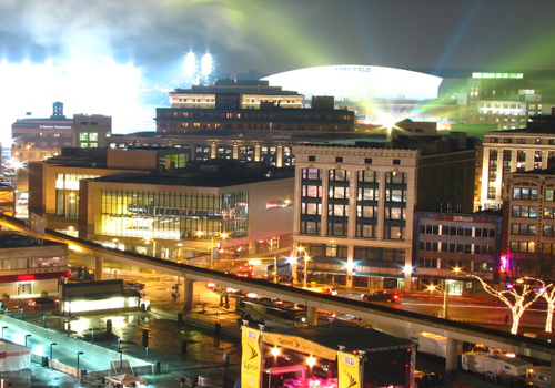 Downtown Detroit lit up at night, Ford Field in distance very bright