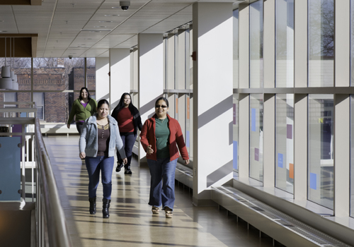 Four women walking down hallway