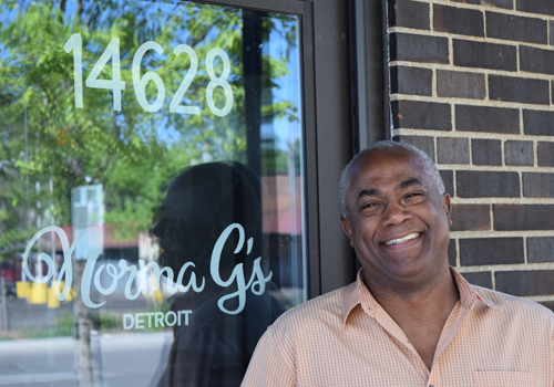 Man smiling in front of storefront #14628, Norma Gs