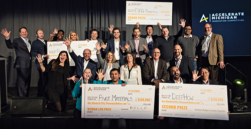 Many people posing on a stage with oversized checks
