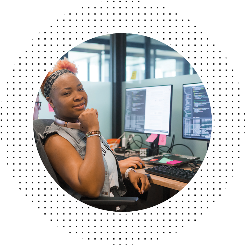 Woman smiling at camera in front of computers